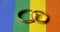 Same-sex marriage concept - two wedding rings on lgbt rainbow flag