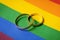 same-sex marriage concept - wedding rings on lgbt rainbow flag