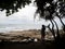 Samed, Thailand. Silhouette of Asian woman traveler by rock beach looking away.