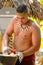 A Samoan man demonstrating how to prepare a dish of banana in coconut milk