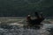 Sampan boat-ride, rowed by a villager at Tam Coc , Vietnam : the karst landscape with many vertical