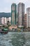 Sampan ferry in front of tall buildings in harbor of Hong Kong, China