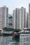 Sampan ferry in front of tall buildings in harbor of Hong Kong, China