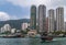 Sampan ferry in front of tall buildings in harbor of Hong Kong, China