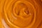 Sample of transparent shower gel on orange background, closeup