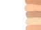 Samples of different foundation shades on white background