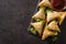 Samsa or samosas with meat and vegetables on black background.