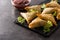 Samsa or samosas with meat and vegetables on black background.