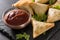 Samsa or samosas with meat and vegetables on black background. Traditional Indian food.