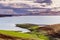 San Luis Reservoir on a stormy day; green grass starting to grow on the shoreline; San Luis Reservoir is a man-made lake storing