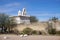 San Xavier Mission white bell tower visible beyond dirty adobe wall near Tucson Arizona