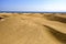 Sand background with space for your decoration. Beautiful sand dunes. Blurred blue sea with sky. Summer time.