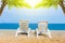 Sand beach with coconut trees with two chairs and bokeh beach tropical background, summer vacation and travel ideas, relaxation