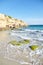 Sand beach near cliff, summer sea with blue sky. Sea water with white wave. Cala azzurra beach, Favignana island, Trapani, Sicily