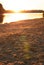 Sand beach of river with evening sun light glare unfocused vertical photo