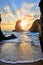 Sand beach among rocks on evening sunset