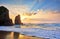 Sand beach among rocks on evening sunset