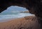 Sand beach with sandstone window and foot prints and cliffs