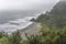 Sand beach, steep rocky shore and Tasman sea waves and froth, near Perpendicular Point, West Coast, New Zealand