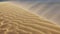 Sand blowing over the dunes in the desert