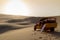 Sand boarding ,Dune Buggy parked in the desert during sunset at Huacachina Oasis in Ica, Peru