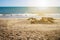 Sand castle on beach. Summer and holiday time. Relax. Sun is shining above the sea level.