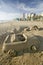 Sand castle of car with cup holder on beach with Durban skyline in the background, South Africa