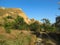 Sand cliffs, blue sky, acacia and unpaved road