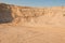 Sand cliffs in industrial quarry background