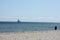 Sand on desert beach close-up and sea sailboat on horizon