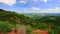 Sand Dune Crest Over Green Hilly Valley against Cloudy Blue Sky