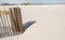 Sand dune fence by rippled sand