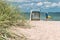 Sand dune with grass and blue colored roofed chairs on sandy beach and blurred kids in Background. Travemunde. Germany