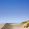 Sand Dune with Grass and Blue Sky