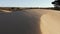 Sand dune with wind energy windmill on a windy day at the beach in Sidi Kaouki, Essaouira, Morocco.