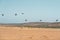 Sand dunes on the beach and group of flying pelicans