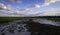 Sand dunes, marshland and clouds on blue sky background