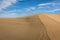 Sand in the Dunes of Maspalomas, a small desert on Gran Canaria, Spain. Sand blowing in the wind on top of the hill.