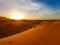 Sand dunes of Sahara desert morocco during scenic sunset with golden yellow sunlight