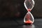 Sand passes through an hourglass, measuring the travel time counting down to the deadline, against a dark background with space