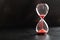 Sand passes through an hourglass, measuring the travel time counting down to the deadline, against a dark background with space