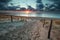 Sand path to North sea beach at sunset
