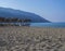 Sand and pebbles beach and turquoise sea shore at Agios Georgios Pagon at Corfu island, Greece with sun umbrellas orange