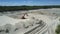 Sand pit with high hills and red digger in summer upper view