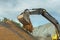 Sand pouring from scoop of excavator