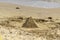 Sand pyramid on the beach by the sea