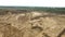 Sand quarry in countryside. Scene. Top view of empty yellow quarry with roads and pits on background of greenery and