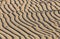 Sand ripple waves in the desert or on the beach on sunny day. Sandy desert abstract texture background at sunset. Windy day