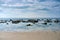 Sand and rock beach against the blue sky with stratocumulus clouds on Tarifa coast