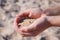 Sand spills out of the hands. On the beach near